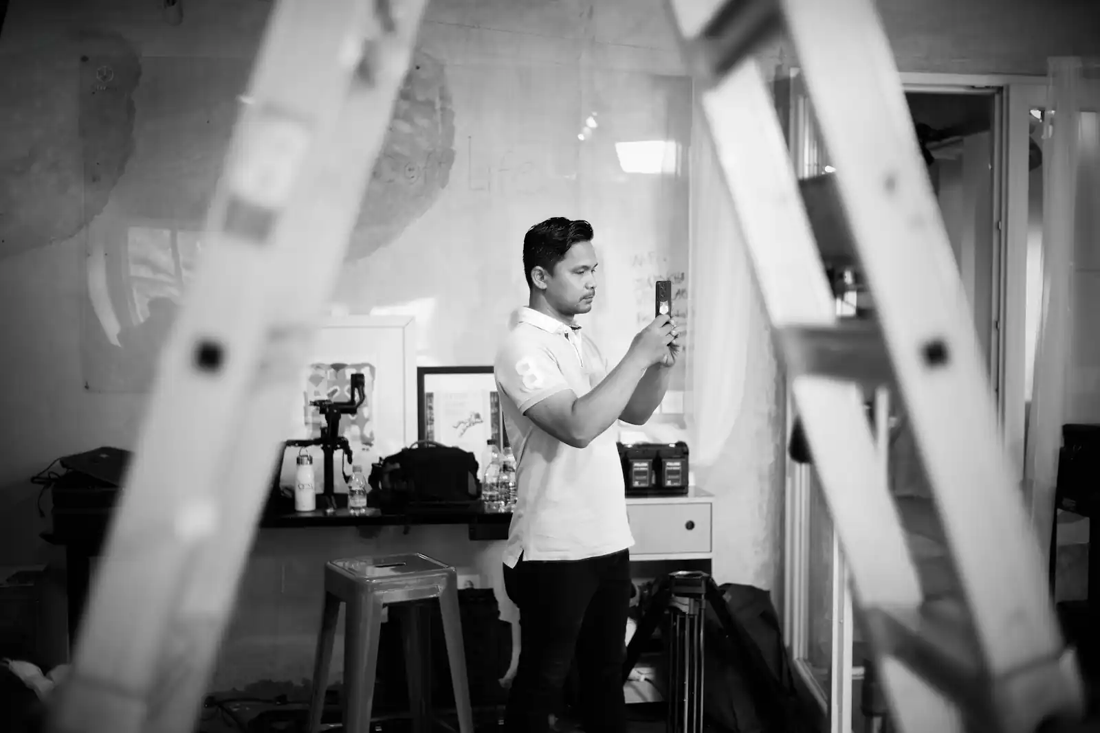 A tradesperson on site next to a ladder, checking progress on a job